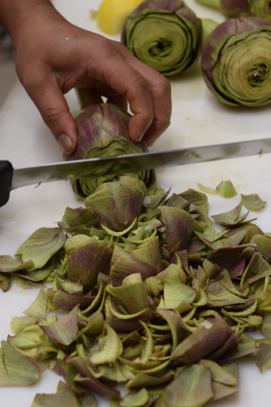 Carciofi tagliati al coltello sul tagliere